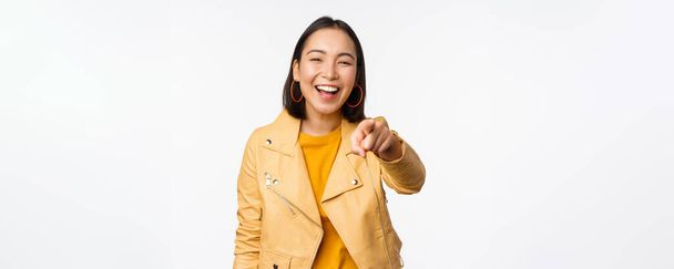Congratulations, its you. Happy beautiful asian woman laughing, pointing finger at camera, choosing, inviting people, recruiting, standing over white background - Photo, Image