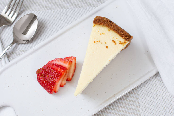 A top down view of a slice of New York style cheesecake. - Фото, изображение