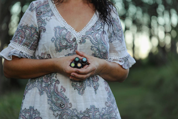 Firefly NSW Australia - 20 April 2022: Woman in forest holding bundle of doterra essential oils, no face visible - Fotó, kép