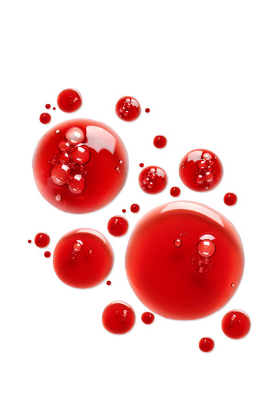 Gotas de produto cosmético vermelho sobre fundo branco - Foto, Imagem