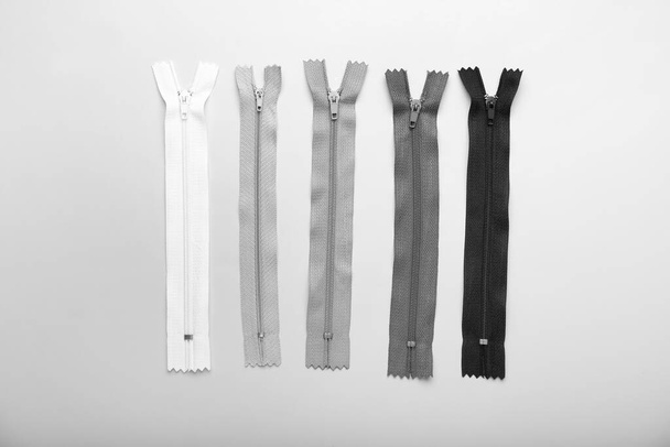 Stylish different zippers on light background - Fotó, kép