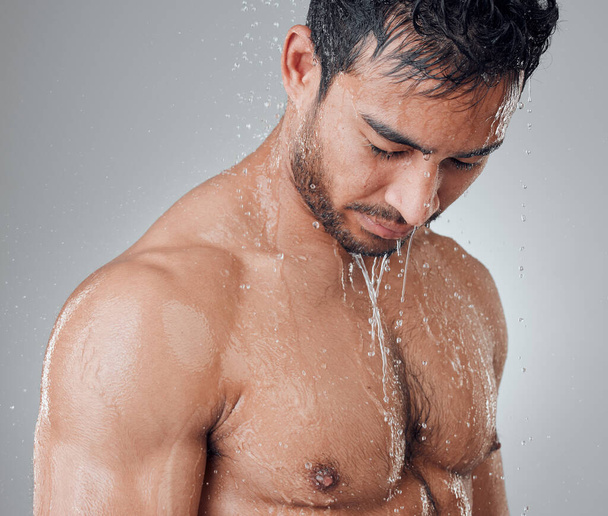 Uzun bir duşla kendine çeki düzen ver. Gri bir arka planda duş alan genç bir adamın fotoğrafı.. - Fotoğraf, Görsel
