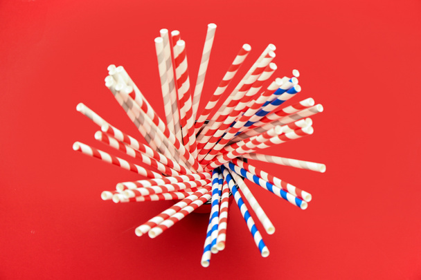 Cup with stylish straws for drinks on red background - Photo, Image