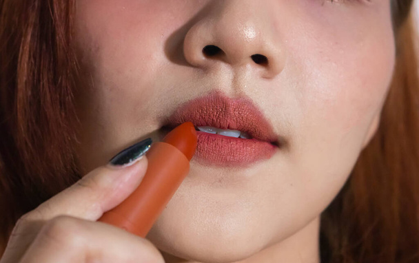 Close up portrait model applying dark red lipstick.. Professional fashion retro make-up. - Photo, image
