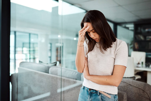 İşyeri stresi endişe ve depresyon için büyük bir risk faktörüdür. Ofiste stresli görünen genç bir iş kadınının fotoğrafı.. - Fotoğraf, Görsel