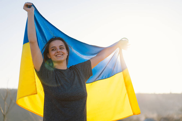 Nő kezében egy sárga és kék zászló Ukrajna a szabadban - Fotó, kép