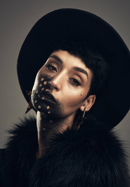 Confidence is contagious. Studio shot of a young woman posing with paint on her face on a grey background. - Fotoğraf, Görsel