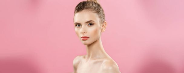 Concepto de belleza - Hermosa mujer con piel limpia y fresca de cerca en el estudio rosa. Cuidado de la piel. Cosmetología
. - Foto, Imagen