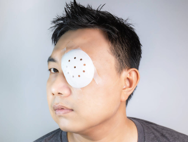 Asian men wear eye masks, sun protection, dust masks, masks after treatment or surgery, resulting in reduced vision even with small holes. Store in a cool dry place away from direct sunlight. - Photo, image