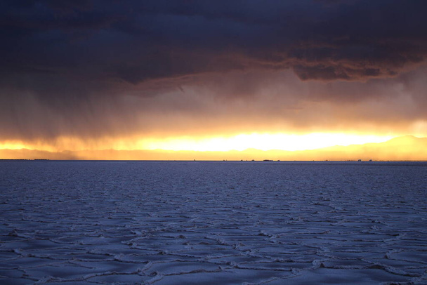 Storm at salt flat desert on sunset - Фото, изображение