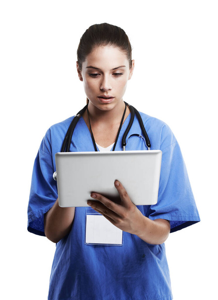 Diagnóstico digital. Captura de estudio de un hermoso médico joven usando una tableta digital contra un blanco. - Foto, imagen