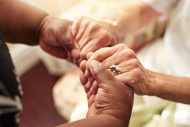 Laskavost. Zaplať dopředu. Vystřižený záběr starší ženy drží své přátele ruce v pohodlí. - Fotografie, Obrázek