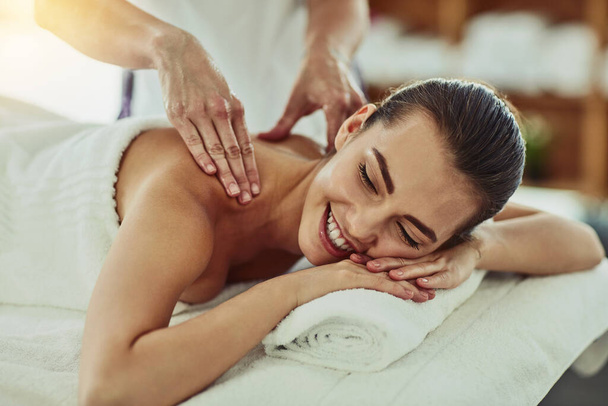 Massage doet het lichaam goed. Shot van een aantrekkelijke jonge vrouw krijgen gemasseerd in een beauty spa. - Foto, afbeelding