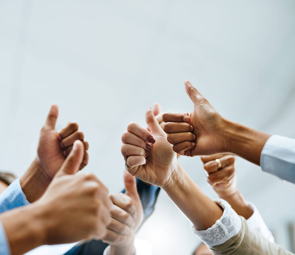 We absolutely love what youre doing. Shot of a group of unrecognisable businesspeople showing thumbs up in an office. - Foto, Imagem