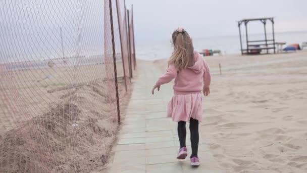 Ein kleines Mädchen läuft auf dem Weg zum Meer - Filmmaterial, Video