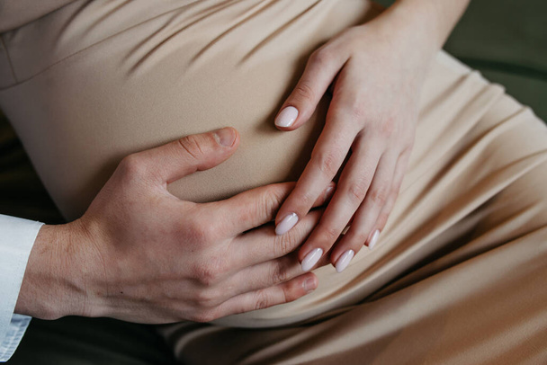 Pregnancy background. Pregnant belly on a black background - Foto, imagen