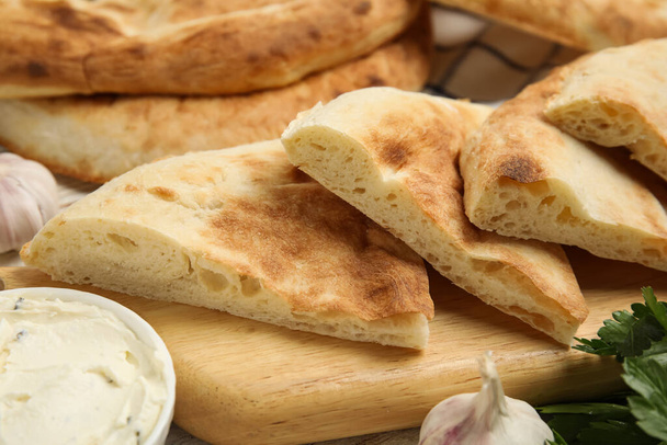 Pieces of fresh pita bread and cream cheese on table, closeup - Foto, immagini