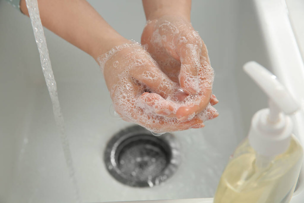 Woman washing hands with liquid soap, closeup - Foto, afbeelding