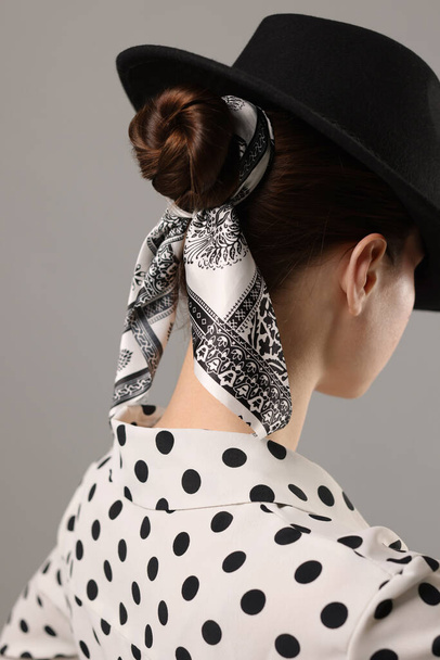 Woman with black hat and stylish bandana on light grey background - Fotoğraf, Görsel
