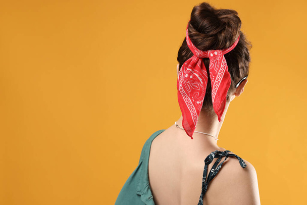Woman with stylish bandana on yellow background. Space for text - Fotó, kép