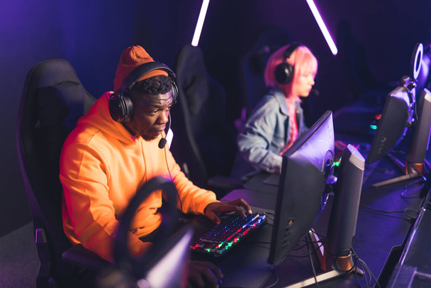 Afro-American and Asian hipster players playing video games copy space cyberspace  - Foto, imagen