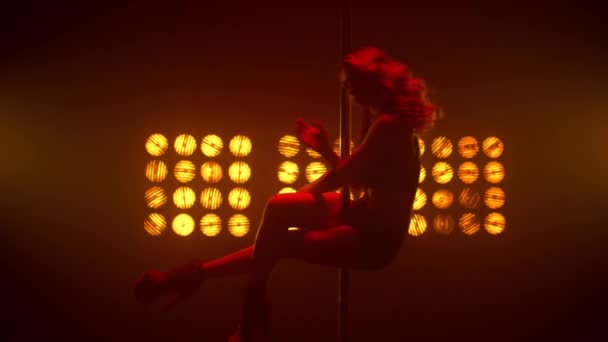 Hot woman pole dancing in front spotlights night club. Dáma dělá erotické pohyby. - Záběry, video