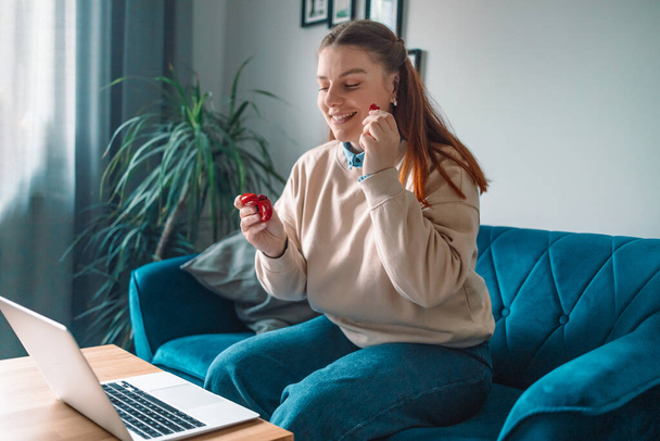 freelancer woman hands with red wireless earphones stay home sit cozy couch living room indoors - Foto, imagen