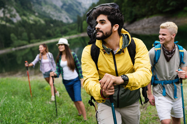 Group of happy fit young friends hiking, trekking together outdoor nature - Foto, afbeelding