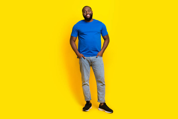 Full length body size view of attractive cheerful guy holding hands in pockets isolated over bright yellow color background - Zdjęcie, obraz