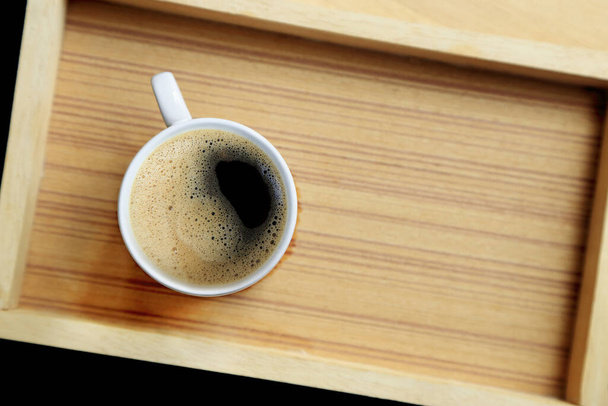 Kávový šálek s krémem na dřevěném pozadí, horní pohled s kopírovacím prostorem. - Fotografie, Obrázek