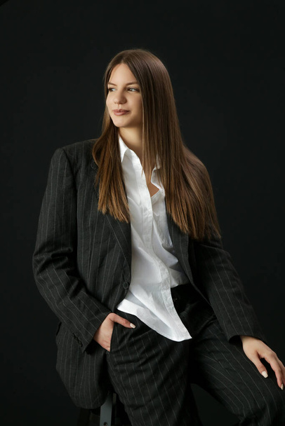 Studio portrait of fashionable girl in white button down shirt and striped oversized suit. - Fotografie, Obrázek