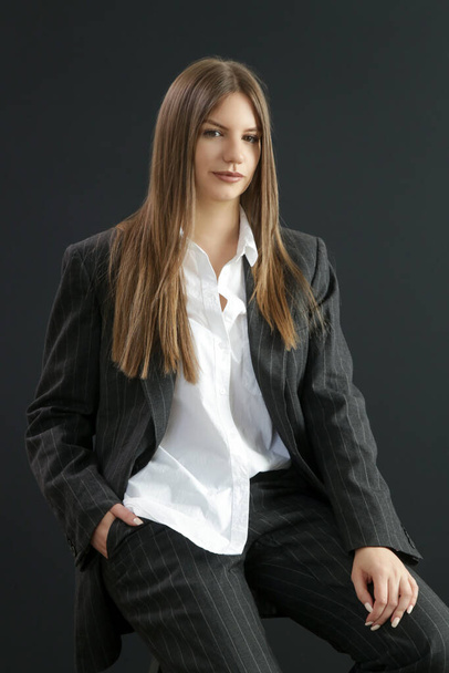 スタジオポートレートのファッショナブルな女の子でホワイトボタンダウンシャツとストライプ特大スーツ. - 写真・画像