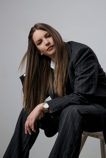 Studio portrait of fashionable girl in white button down shirt and striped oversized suit. - Photo, Image