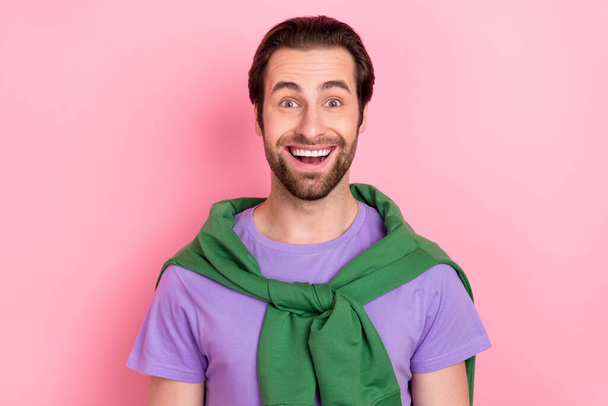 Photo of impressed young brunet man look camera wear purple t-shirt isolated on pink color background - Photo, image