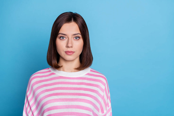 Photo of serious confident young lady dressed pink pullover empty space isolated blue color background - Foto, immagini