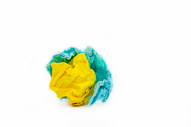 lump of yellow and blue crumpled paper on a white background as symbols of Ukraine, the war in Ukraine - Photo, Image