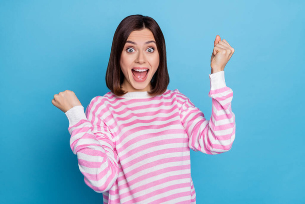 Photo of pretty lucky lady dressed pink pullover screaming rising fists isolated blue color background - Zdjęcie, obraz
