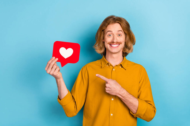 Portrait of attractive trendy cheerful long-haired guy holding demonstrating like card rate isolated over bright blue color background - Photo, Image