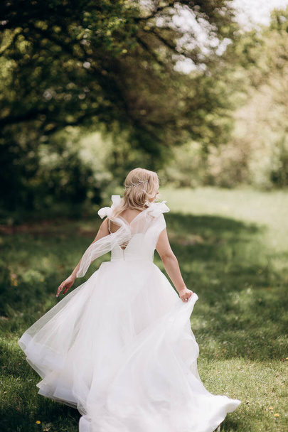 bride in a wedding dress runs in nature - Foto, Imagen
