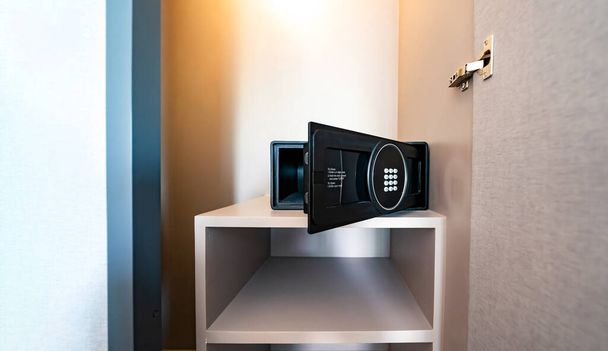 Opened Unlock digital modern Black Safe box, Stroungbox on the shelf in wood Closet in Hotel room  - Foto, imagen