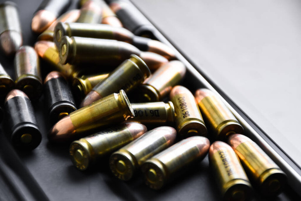 Pile of 9mm pistol bullets on taplet keyboard and screen, soft and selective focus, concept for learning types of bullets by using smart devices to search and store the database. - 写真・画像
