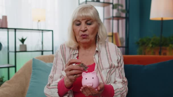 Triste anciana pobre contando el dinero de Piggybank sosteniendo último un dólar en efectivo, deuda de pobreza - Imágenes, Vídeo