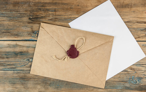 запечатанный коричневый конверт на деревянном фоне
 - Фото, изображение