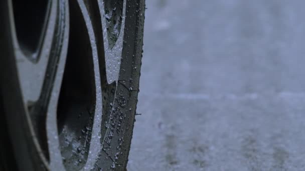Rain splashing and car tire in rainwater. Car parking in the rain. Raining season and tires on the wet pavement. Close up of car tyre or wheels on a wet road. Represent auto in rainy season concept. - Séquence, vidéo