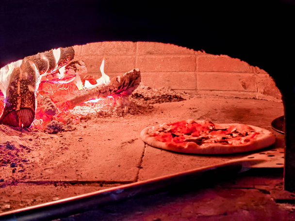 pizza nourriture chaude dans le four avec bois et feu frais préparation cuisine intérieure - Photo, image