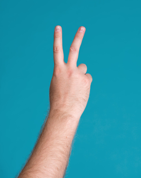 Mão com dois dedos para cima no símbolo de paz ou vitória
 - Foto, Imagem