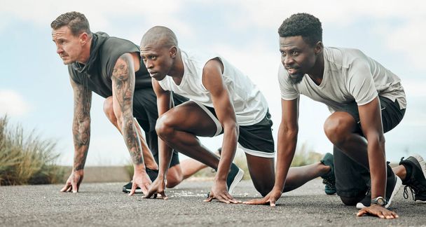 Your only competition is against who you were yesterday. Shot of a group of men getting ready to start a race. - Photo, Image