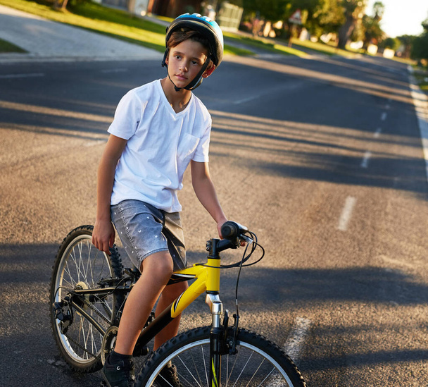 Pyöräilemässä korttelin läpi. Nuori poika ajoi pyörällään naapuruston halki.. - Valokuva, kuva