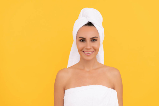 happy young woman with towel after shower on yellow background - Photo, Image