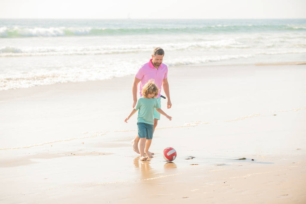 οικογένεια χαμογελαστός μπαμπάς άντρας και παιδί αγόρι παίζουν μπάλα στην παραλία, καλύτεροι φίλοι - Φωτογραφία, εικόνα